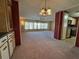 Spacious living room featuring neutral carpet, ample natural light, and decorative chandelier at 1209 Apache Cir, Tavares, FL 32778