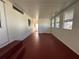 Spacious, bright screened porch with red floor, white walls and ceiling, and multiple windows for natural light at 1209 Apache Cir, Tavares, FL 32778