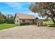 Charming home with a well-maintained lawn, gravel driveway, and mature landscaping, set against a bright sky at 26348 Se Highway 42, Umatilla, FL 32784