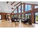 Open living room boasts hardwood floors, vaulted wood ceilings, and large windows with beautiful outdoor views at 26348 Se Highway 42, Umatilla, FL 32784