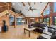 Cozy living room with hardwood floors, vaulted wood ceilings, stone fireplace, and an adjacent kitchen area at 26348 Se Highway 42, Umatilla, FL 32784