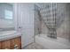 Bathtub with tile surround and striped shower curtain in a bright bathroom at 3114 Jemima Ave, The Villages, FL 32163