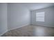 Bedroom with light grey wood floors and a window allowing natural light at 3114 Jemima Ave, The Villages, FL 32163