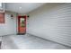 Covered front porch with a stained front door, two black lanterns, and beige siding at 3114 Jemima Ave, The Villages, FL 32163