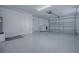 Spacious three-car garage with speckled epoxy flooring and washer-dryer at 3114 Jemima Ave, The Villages, FL 32163