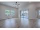 Living room features wood flooring, a ceiling fan, and sliding glass doors to the pool at 3114 Jemima Ave, The Villages, FL 32163
