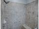A tiled walk-in shower featuring a handheld shower head, built-in seat, and modern fixtures at 3114 Jemima Ave, The Villages, FL 32163