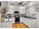 Bright kitchen featuring white cabinets, stainless steel appliances, gray countertops, and natural wood flooring at 7313 Stetson Dr, Clermont, FL 34714