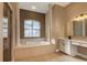 Bathroom showcasing a large soaking tub, vanity, and glass-enclosed shower at 27303 Gingerbread Pl, Leesburg, FL 34748