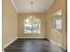 Bright dining room with dark wood floors, large window, and elegant chandelier at 27303 Gingerbread Pl, Leesburg, FL 34748
