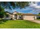 Beautiful home featuring a well-manicured lawn, two-car garage, and freshly painted exterior at 27303 Gingerbread Pl, Leesburg, FL 34748