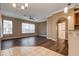 Open-concept living room with wood floors, large windows, and modern ceiling fan at 27303 Gingerbread Pl, Leesburg, FL 34748