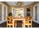 Charming patio area featuring a wooden table set, ceiling fan, and access through elegant french doors at 27303 Gingerbread Pl, Leesburg, FL 34748