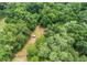Aerial view of a property with lush trees and fenced area at 11635 Se Highway 42, Weirsdale, FL 32195