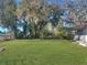 Large backyard with lush grass and oak trees at 11635 Se Highway 42, Weirsdale, FL 32195