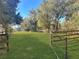 Fenced-in backyard with mature trees at 11635 Se Highway 42, Weirsdale, FL 32195