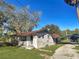 Ranch-style home with carport and mature landscaping at 11635 Se Highway 42, Weirsdale, FL 32195