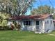 Quaint ranch home with a red roof and well-manicured lawn at 11635 Se Highway 42, Weirsdale, FL 32195