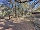 Wooded pasture with a rustic fence and old farm equipment at 11635 Se Highway 42, Weirsdale, FL 32195