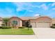 Charming single-story home featuring a well-manicured lawn and a two-car garage at 3506 Mulberry Grove Loop, Leesburg, FL 34748