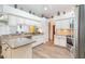 Well-lit kitchen with granite counters, white cabinets, stainless steel appliances, and light wood-look floors at 3506 Mulberry Grove Loop, Leesburg, FL 34748