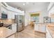 Bright kitchen features stainless appliances, granite counters, tiled backsplash, breakfast nook, and light wood-look floors at 3506 Mulberry Grove Loop, Leesburg, FL 34748