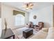 Cozy living room with ceiling fan, large window, neutral carpet, plush furniture, and stylish decor at 3506 Mulberry Grove Loop, Leesburg, FL 34748