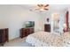 Spacious main bedroom with plush carpet, ceiling fan, dresser, and views from the large window at 3506 Mulberry Grove Loop, Leesburg, FL 34748