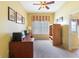 Sunny office with neutral carpet, ceiling fan, built-in shelves, and a large window with custom blinds at 3506 Mulberry Grove Loop, Leesburg, FL 34748