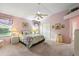 Cozy bedroom featuring soft lighting, floral bedding, and closet at 1306 De La Garza Pl, The Villages, FL 32162