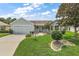 Charming single-story home featuring a well-manicured lawn and a two-car garage at 1306 De La Garza Pl, The Villages, FL 32162