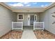 Inviting front porch featuring a seating area with white railing that offers a cozy spot to enjoy the outdoors at 1306 De La Garza Pl, The Villages, FL 32162