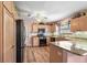 Well-equipped kitchen with stainless steel appliances, granite countertops, and light wood cabinetry, perfect for cooking and entertaining at 1306 De La Garza Pl, The Villages, FL 32162