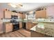 The kitchen features granite countertops, modern appliances, wood cabinets, and ample counter space for meal preparation at 1306 De La Garza Pl, The Villages, FL 32162