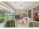 Enclosed lanai with seating, TV, ceiling fan, and view of the backyard at 1306 De La Garza Pl, The Villages, FL 32162