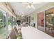 Enclosed lanai with a dining table, chairs, and multiple ceiling fans at 1306 De La Garza Pl, The Villages, FL 32162