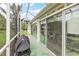 Enclosed lanai with grill, seating, and backyard view at 1306 De La Garza Pl, The Villages, FL 32162
