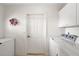 Bright laundry room with side-by-side washer and dryer, freezer, and storage at 1306 De La Garza Pl, The Villages, FL 32162