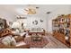 Bright living room featuring stylish wicker furniture, ceiling fan, and hardwood floors at 1306 De La Garza Pl, The Villages, FL 32162