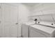 A laundry room with a washer, dryer, and wire shelving for storage at 27227 Roanoke Dr, Leesburg, FL 34748