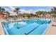 Resort-style pool with lap lanes, pergola, lounge chairs, and palm trees against a sunny sky at 27227 Roanoke Dr, Leesburg, FL 34748