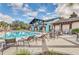 Resort-style pool with comfortable lounge chairs and umbrellas for relaxation, surrounded by lush landscaping at 27227 Roanoke Dr, Leesburg, FL 34748