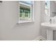 Small bathroom with pedestal sink, large window with natural light and a view outside at 3106 Voyager Ave, St Cloud, FL 34771