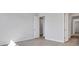 A large bedroom with neutral walls and floors with multiple doors and wall outlets at 3106 Voyager Ave, St Cloud, FL 34771