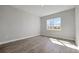 An empty bedroom featuring wood-style flooring, a large window, and a neutral color palette at 3106 Voyager Ave, Saint Cloud, FL 34771