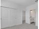 Clean, minimalist bedroom featuring sliding closet doors and a view into a nearby bathroom at 6521 Daypack Ln, St Cloud, FL 34771