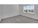 Bright and airy bedroom with a large window, plush carpeting, and a neutral color scheme at 6521 Daypack Ln, St Cloud, FL 34771