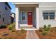 Inviting front porch featuring brick pavers, white columns, and a vibrant red front door at 6521 Daypack Ln, St Cloud, FL 34771