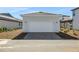 Detached two-car garage with a white door and brick paved driveway in a residential neighborhood at 6521 Daypack Ln, St Cloud, FL 34771