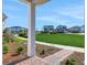 View of the community green and neighborhood homes from the covered front porch with brick pavers at 6521 Daypack Ln, St Cloud, FL 34771